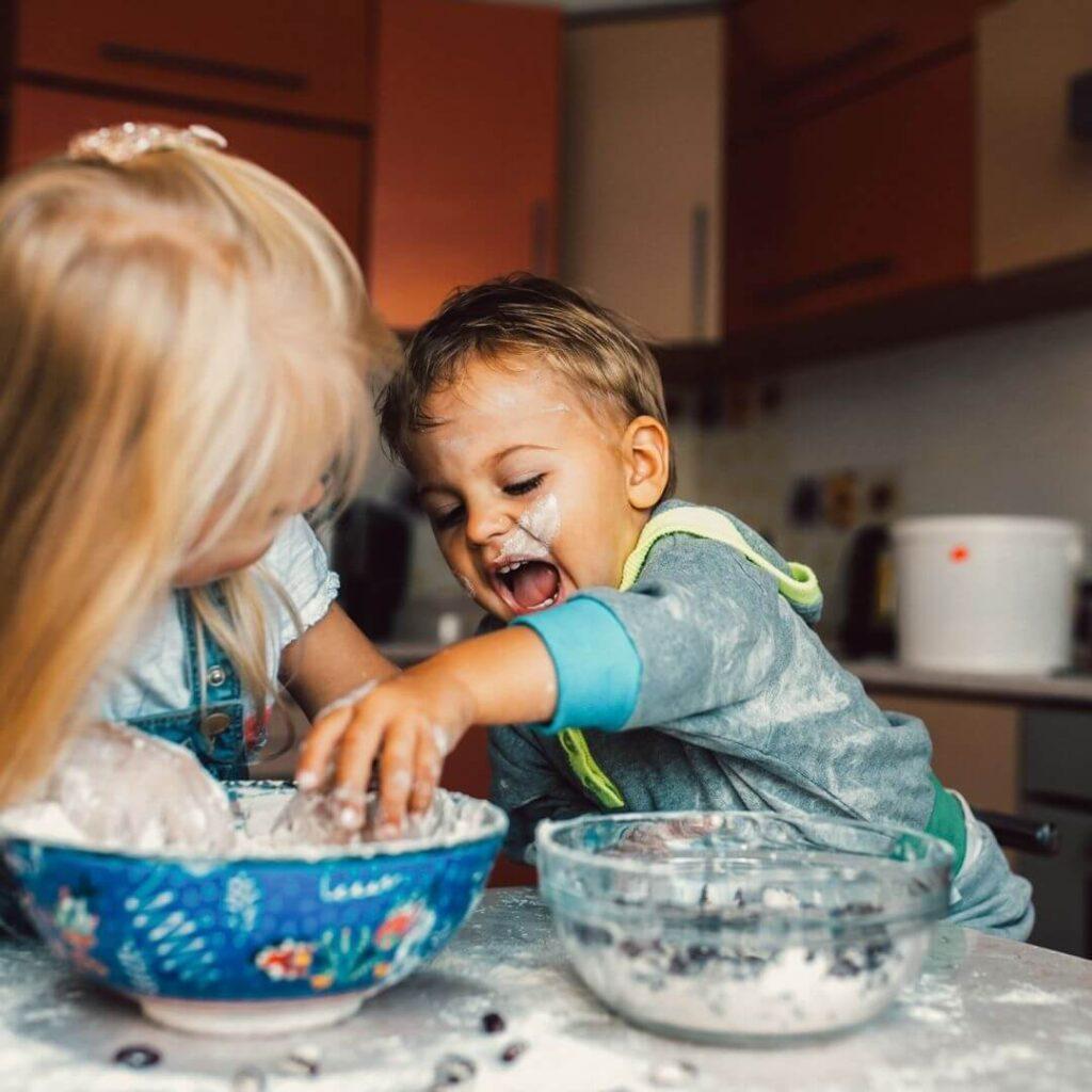η εικόνα δείχνει 2 παιδιά να φτιάχνουν ζυμάρι