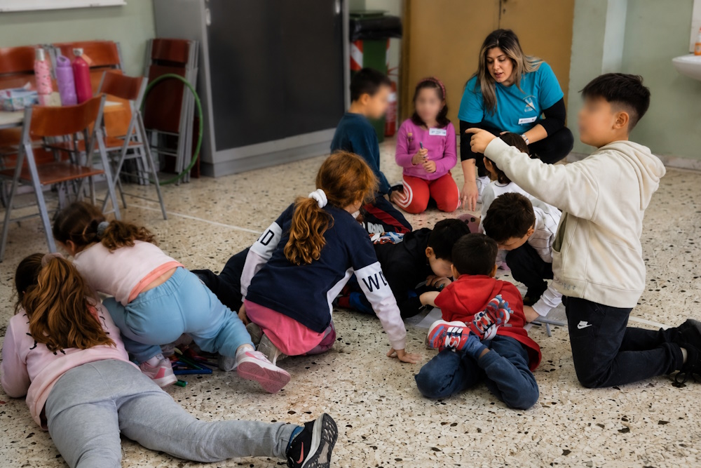 Παιδιά συμμετέχουν σε ομαδική βιωματική δραστηριότητα ανακύκλωσης με την εκπαιδευτικό της EggΠαίδευσης
